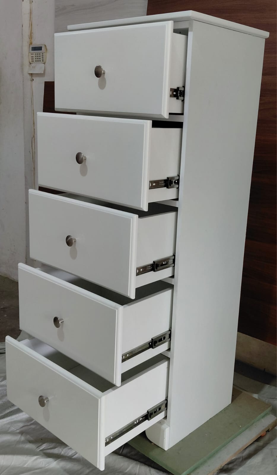 Tall white five-drawer chest with drawers open